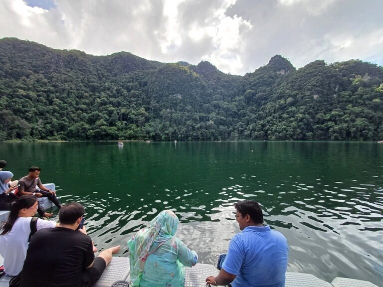Tourists sitting by the edge of Dayang Bunting Lake (Pregnant Maiden Lake) during a Langkawi island hopping tour